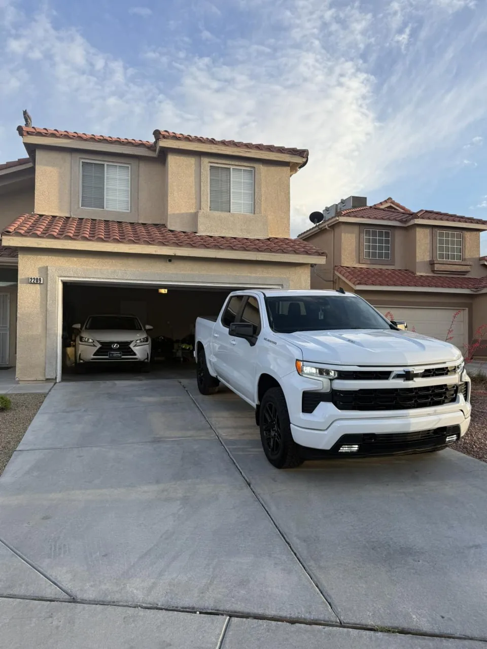 A white pickup parked in the driveway of a house